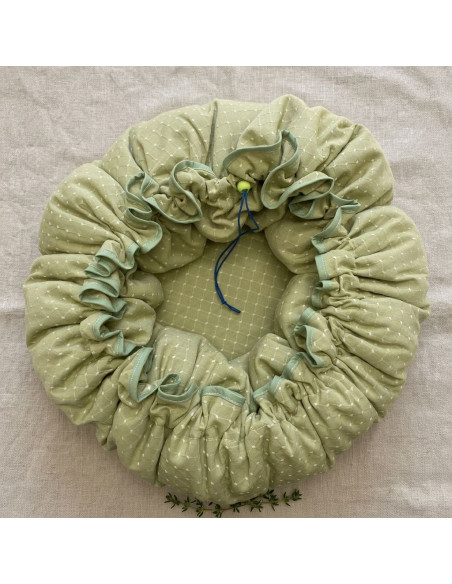 Snood élastique vert clair à pois blancs, profondeur et drapé froncé, fond lin beige. Parfait pour rester au chaud. Marmite norv