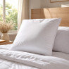Oreiller grand confort 60x60 posé sur un lit