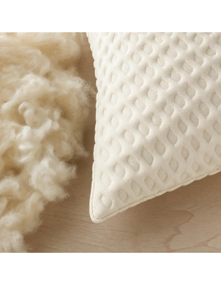 Gros plan du tissu matelassé et de la laine naturelle de l'oreiller garni laine